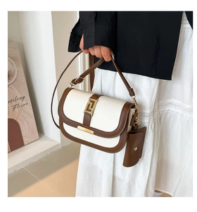 Detailsicht der zweifarbigen Satteltasche mit Goldschnalle und Mini-Tasche