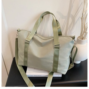 Close-up of light green travel bag showing waterproof nylon fabric and detachable shoulder strap