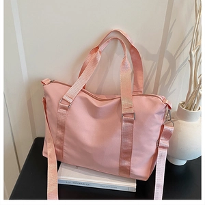 Dettaglio della borsa da viaggio in nylon rosa con doppi manici e tracolla regolabile