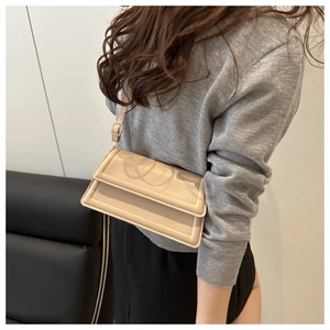Detail of light beige crossbody bag with geometric stitched border and adjustable strap