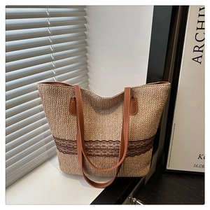 Straw tote bag detail with brown lace trim and leather straps under soft window light