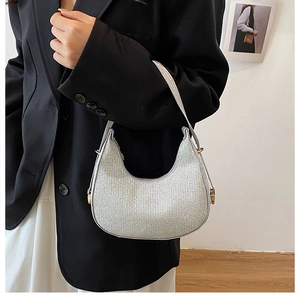 Détail du sac demi-lune argenté pailleté avec fermetures éclair dorées et anse élégante