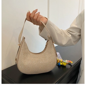 Detail of champagne gold glitter hobo bag with a zipper closure and smooth texture