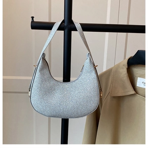 Detailed shot of silver glitter hobo bag with crescent shape and gold metal hardware