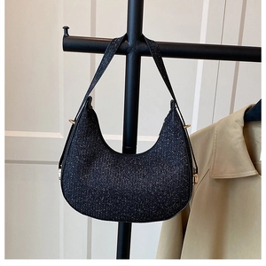 Detail of black glitter hobo bag with crescent shape and gold hardware on a display stand