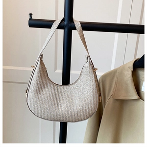 Detailed close-up of champagne gold crescent shoulder bag with metallic glitter texture