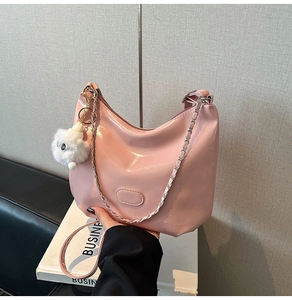 Pink patent leather hobo bag with silver chain strap and plush pendant detail