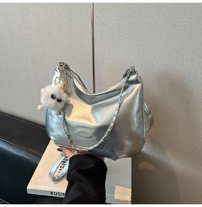 Silberne Metallic-Schultertasche mit Plüschanhänger und Kettenriemen-Detail