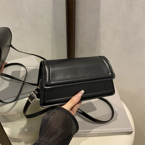 Minimalist black faux leather flap shoulder bag with gold buckle and adjustable strap