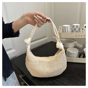 Close-up of beige woven half-moon bag featuring soft knotted handle and metal zipper