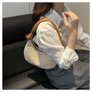 Detail of hand-woven cream crochet hobo bag featuring a brown leather knotted shoulder strap