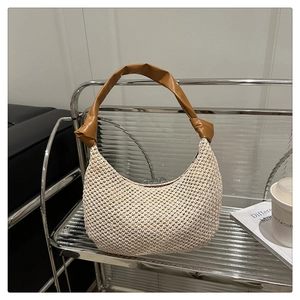 Detail of woven hobo bag with beige mesh texture and brown leather knotted handle