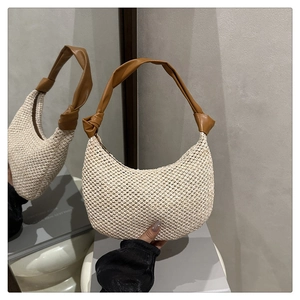 Detailed view of the woven half-moon bag with brown leather knotted strap detail
