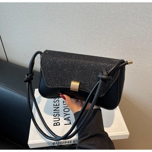 Détail du rabat à paillettes noires et du fermoir doré sur ce petit sac à bandoulière