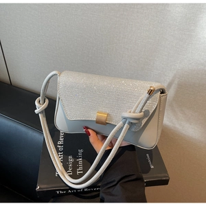 Détails du sac carré gris clair orné de strass brillants et d'un fermoir doré