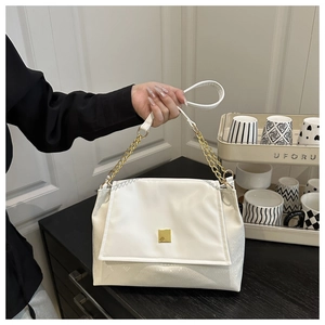 Détail du sac bandoulière blanc en cuir avec matelassage losange et boucle dorée