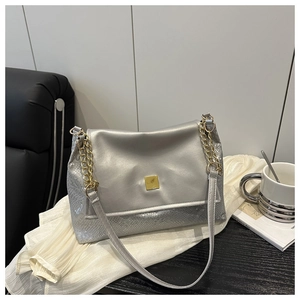 Détail du sac bandoulière argenté avec texture serpent et fermoir à boucle carrée dorée