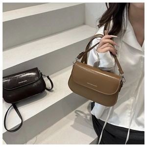 Detail van trendy crossbodytassen in donker- en lichtbruin met gepolijste lederen afwerking