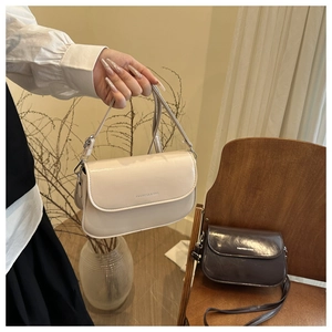 Detail van minimalistische crossbodytassen in crème en bruin met een magnetische flap