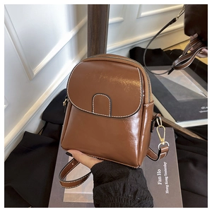 Détail du mini sac bandoulière marron brillant avec surpiqûres blanches et ferrures dorées