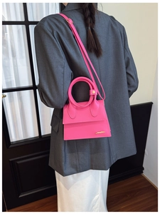 Vue détaillée du sac à main rose en cuir PU avec poignée ronde et logo en métal