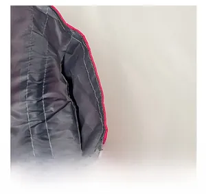 Macro shot of red quilted shoulder bag showing padded material and interior lining
