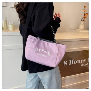 Macro detail of purple canvas tote bag with checkered straps and white letter print