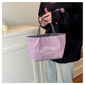 Detail of light purple tote bag with KATONGMU lettering and woven rope handles