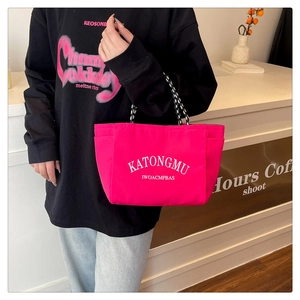 Close-up of bright pink large capacity tote bag with white lettering and sturdy handles