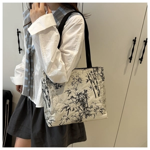 Detailed view of white tote bag with black ink bamboo print and sturdy woven straps
