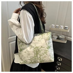 Detail of canvas tote bag featuring green bamboo leaf prints and sturdy webbing handles