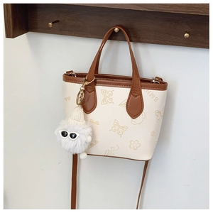 Detail of cream crossbody bucket bag with butterfly embossing and plush charm