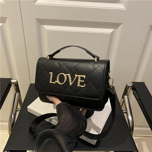 Black quilted cylinder bag with gold LOVE lettering and chain strap for women