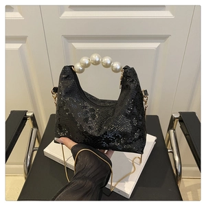 Close-up of black snake pattern leather bag with elegant pearl circular handle