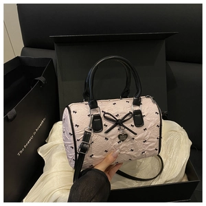 Detail of pink seersucker Boston bag with black bows in a premium gift box setup