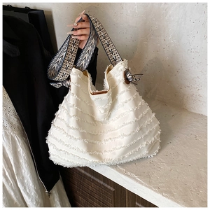 Détail du sac fourre-tout en toile blanc cassé avec franges et bandoulière tissée à motifs