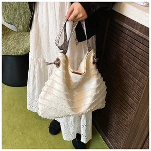 Gros plan du sac hobo blanc à franges avec bandoulière large aux motifs ethniques