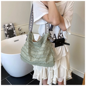 Détail des bords effilochés et du design bohème d'un sac bandoulière en toile vert haricot