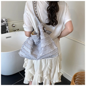 Détail du cabas en toile bleu clair avec franges et bandoulière à motif géométrique