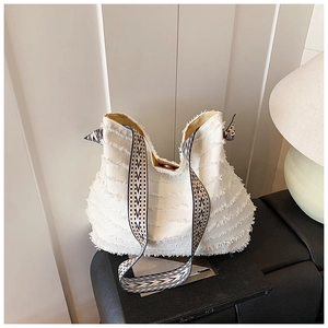 Détail du sac cabas en toile blanche avec franges et bandoulière tissée géométrique