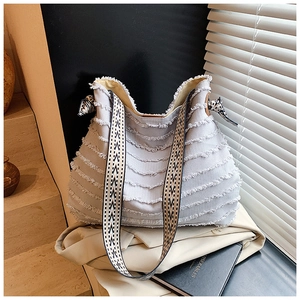 Détail du sac cabas en toile à franges bleu clair avec bandoulière tissée et foulard
