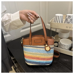 Détails du sac seau tissé à rayures colorées avec anse en cuir marron et finitions dorées