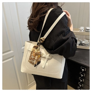 White faux leather tote bag with crocodile pattern and decorative floral scarf on handle