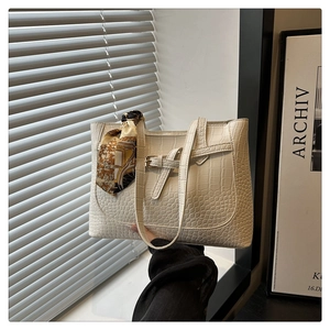 Detail of cream crocodile embossed tote bag with vintage silk scarf on handle