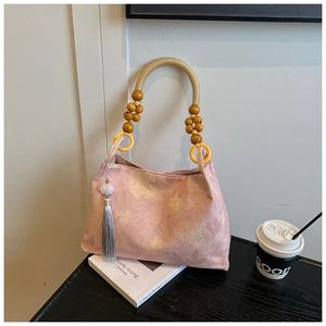Detail of pink floral tote bag with unique beaded wooden handle and grey silk tassel