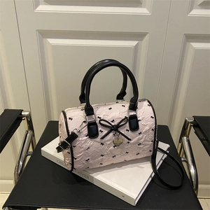 Pink seersucker Boston bag with black bows, leather handles and adjustable strap
