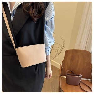 Chic beige bucket bag styled on a wooden chair with a minimalist interior aesthetic