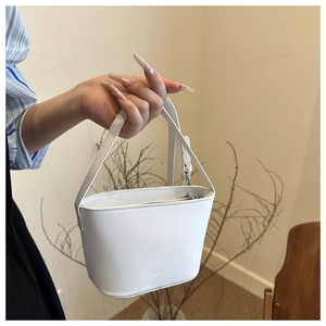 Detail of white mini bucket bag with embossed logo and adjustable shoulder strap