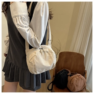 Detail of minimalist corduroy crossbody bags in beige, brown, and black with double zippers