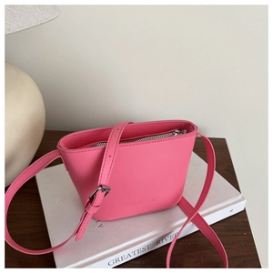 Detail der rosa Leder-Eimertasche mit verstellbarem Gurt und silbernem Metallreißverschluss
